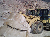 Cat loaders bringing rough stones out of the quarry.